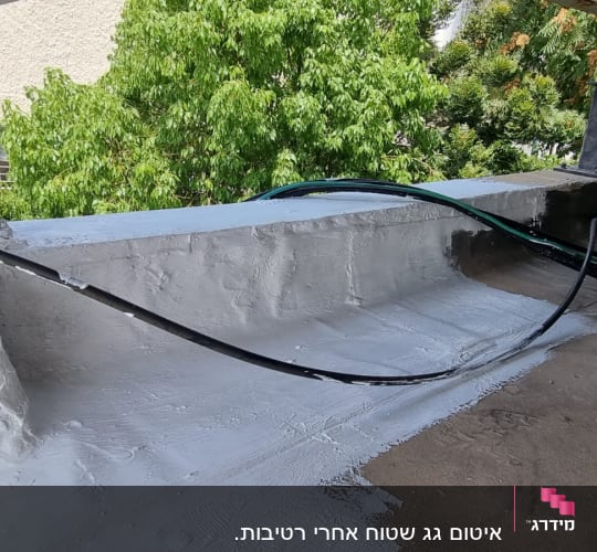 איטום גג עם חומר לבן וכבלים שחורים